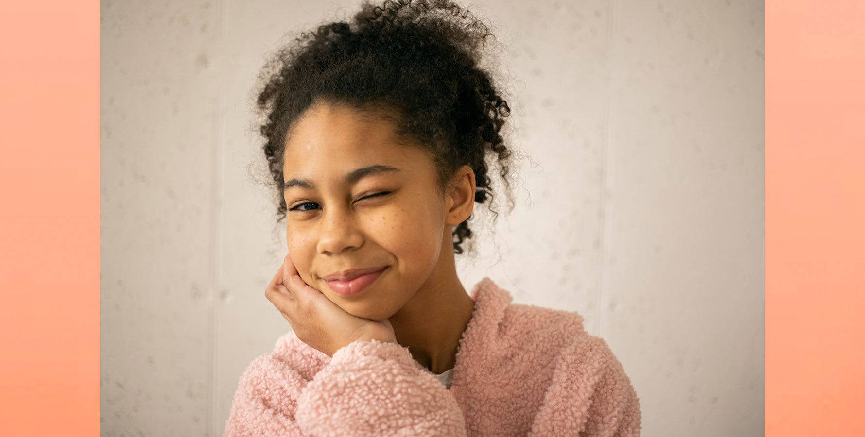 Young Black woman smiling at camera and winking. Cerm Skin Azelaic vs Niacinamide blog post. Photo by Monstera Production: https://www.pexels.com/photo/cheerful-black-girl-winking-at-camera-7114452/